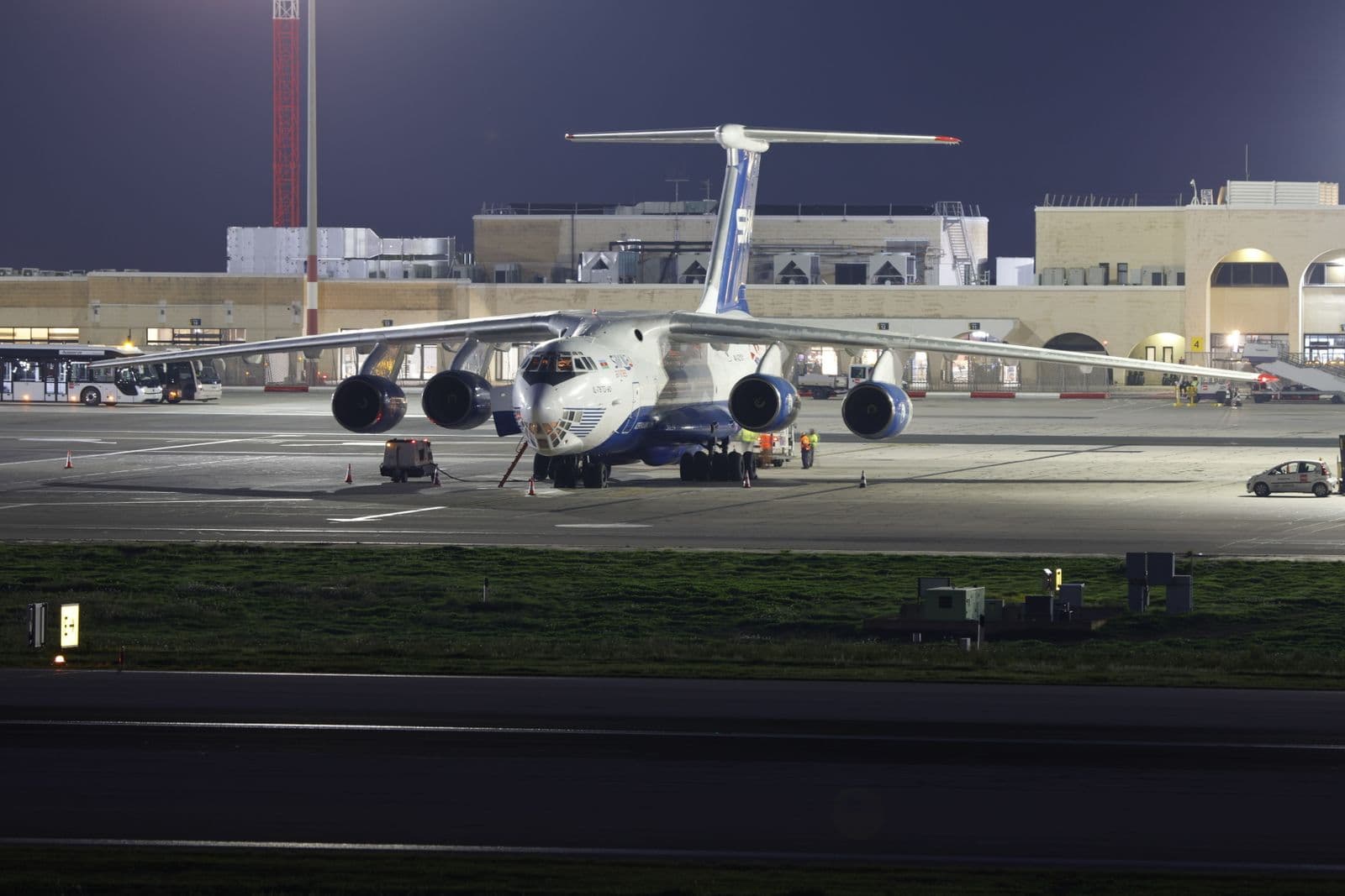 Avión de carga en plataforma durante operación nocturna